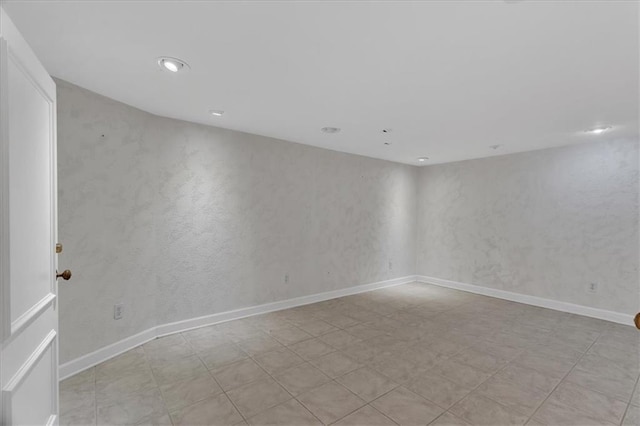 empty room featuring recessed lighting and baseboards