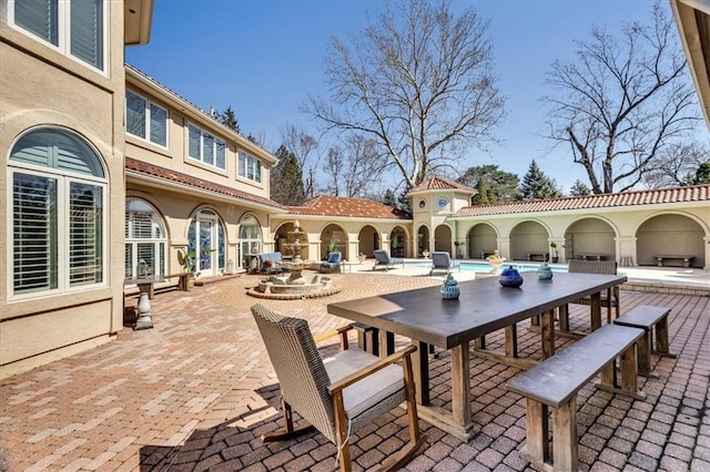 view of patio / terrace featuring outdoor dining space, french doors, and an outdoor pool