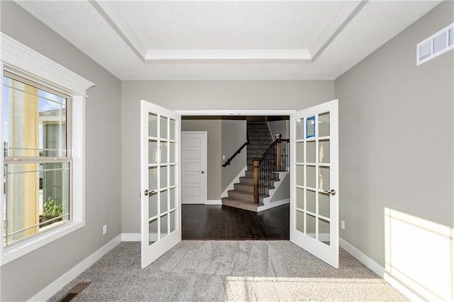 interior space with carpet flooring, visible vents, baseboards, stairs, and french doors