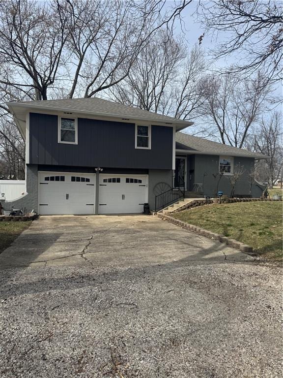 split level home with driveway, a front lawn, and an attached garage