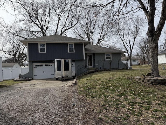 split level home with an attached garage, a front lawn, fence, driveway, and a gate