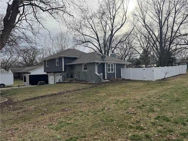 rear view of house featuring a yard, a chimney, and fence