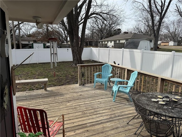 wooden terrace with a fenced backyard