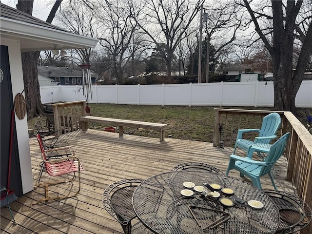 wooden terrace with outdoor dining area and a fenced backyard