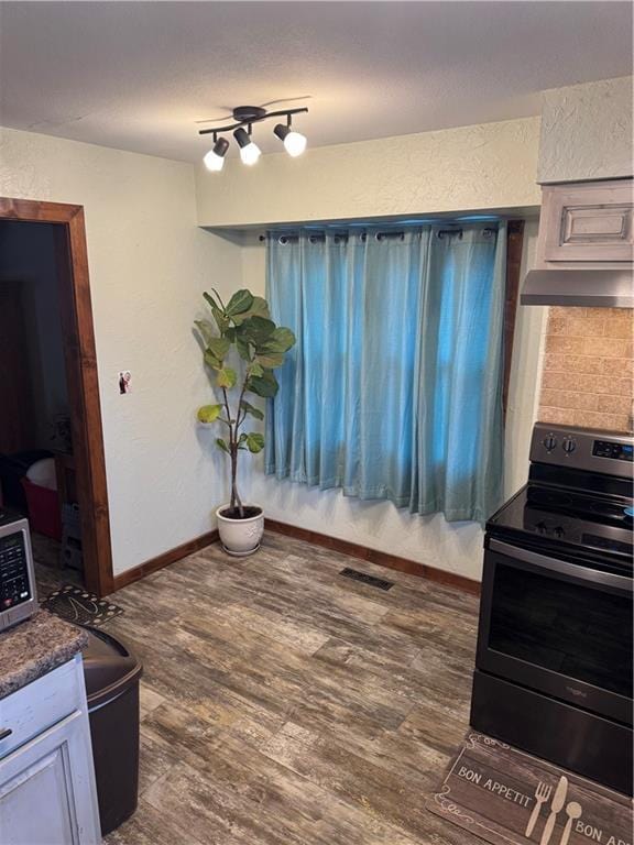 dining area featuring rail lighting, baseboards, and dark wood-style flooring