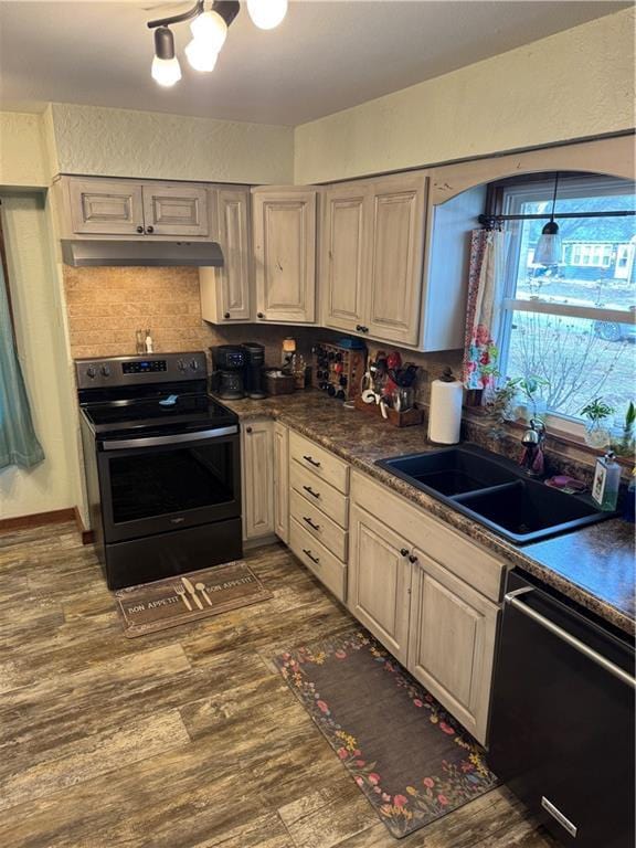 kitchen featuring dark wood-type flooring, under cabinet range hood, dishwasher, stainless steel range with electric cooktop, and a sink