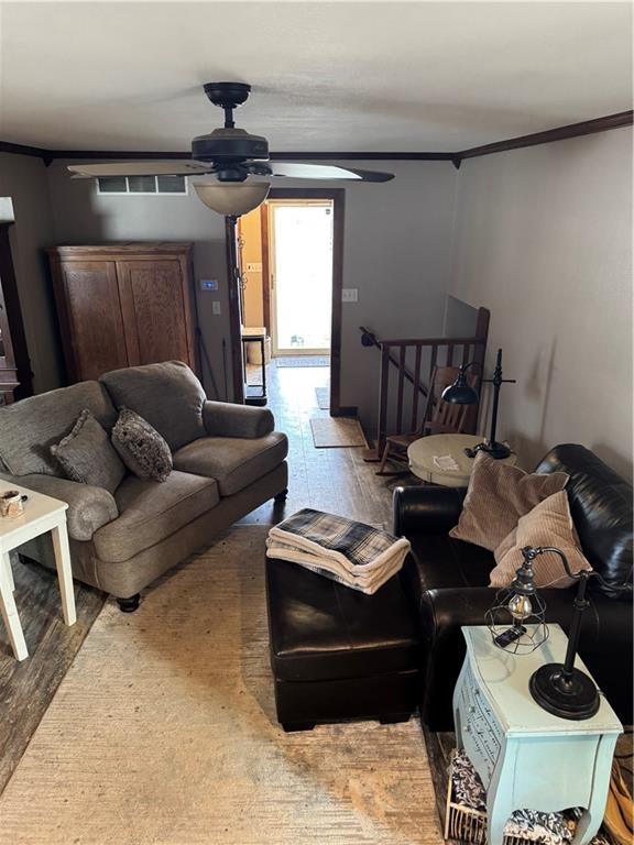 living room with crown molding and a ceiling fan