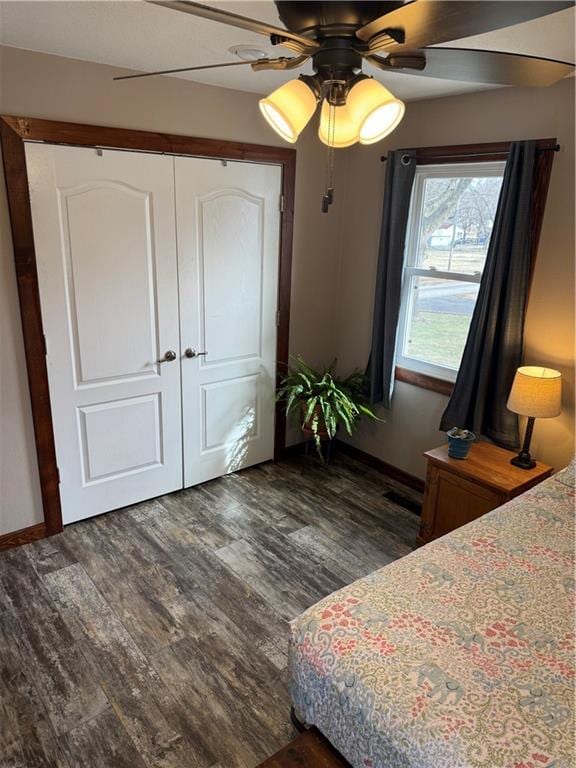 bedroom with dark wood finished floors, a closet, and a ceiling fan