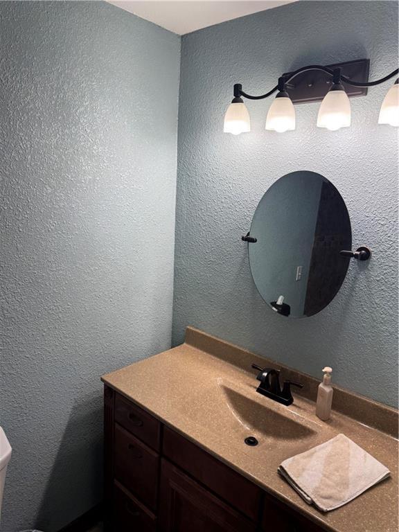 bathroom featuring vanity and a textured wall