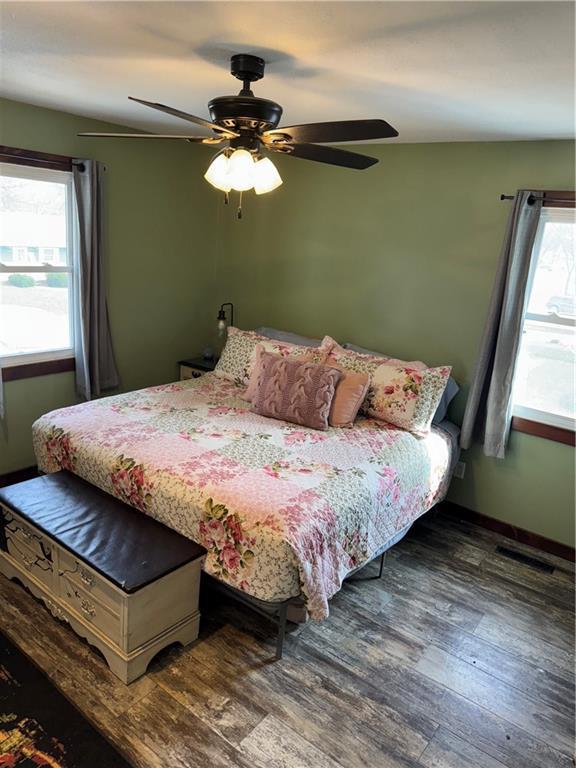 bedroom with visible vents, ceiling fan, and wood finished floors