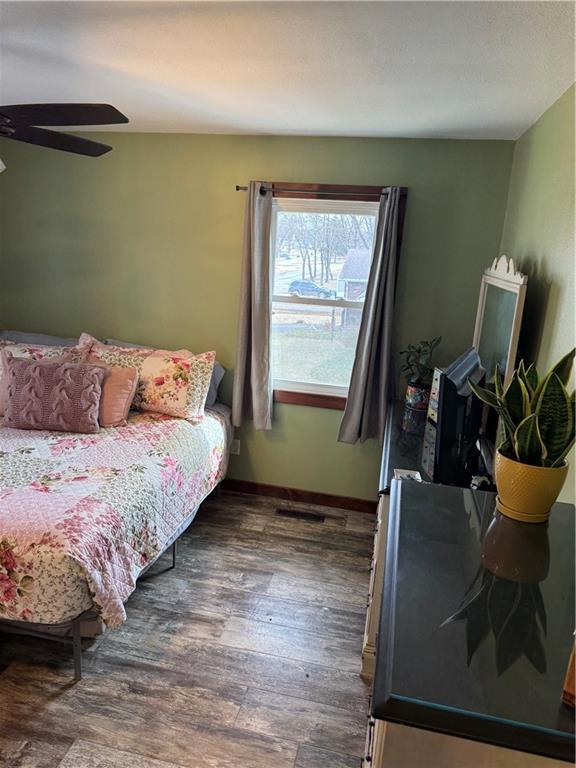 bedroom featuring a ceiling fan, wood finished floors, and baseboards