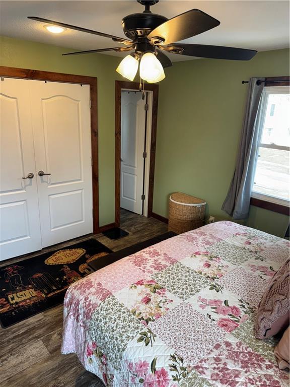 bedroom featuring a ceiling fan, wood finished floors, a closet, and baseboards