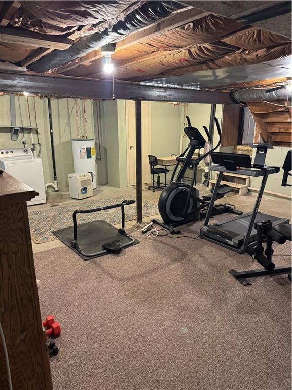 workout area featuring electric water heater and washer and clothes dryer