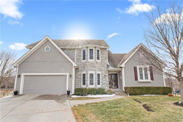 traditional home featuring roof with shingles, concrete driveway, an attached garage, stone siding, and a front lawn