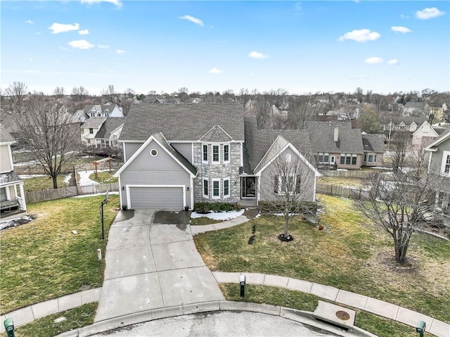 traditional home featuring stone siding, fence, driveway, and a front lawn