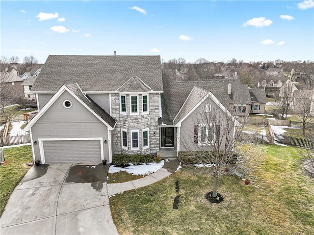 traditional-style house featuring driveway, a garage, fence, and a front lawn