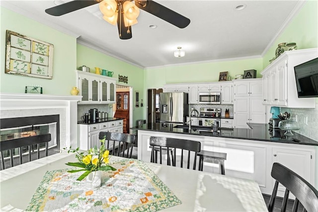 dining area featuring crown molding and a glass covered fireplace