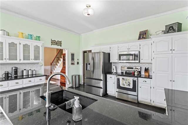 kitchen with stainless steel appliances, a sink, and ornamental molding