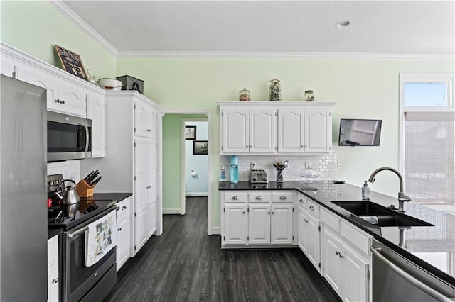 kitchen featuring crown molding, white cabinetry, stainless steel appliances, and a sink