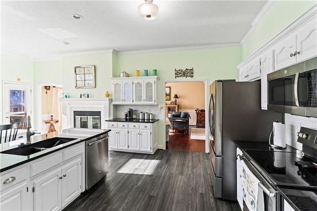 kitchen featuring stainless steel appliances, a sink, white cabinets, decorative backsplash, and crown molding