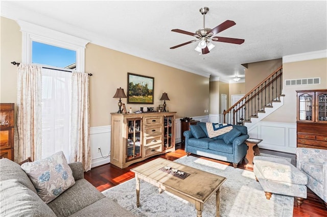 living room featuring stairs, a wainscoted wall, wood finished floors, and visible vents