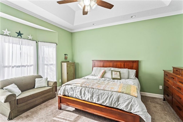 carpeted bedroom featuring ceiling fan, ornamental molding, a raised ceiling, and baseboards