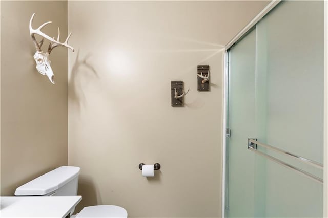 full bathroom featuring a stall shower, vanity, and toilet