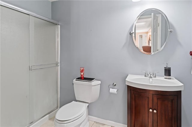 bathroom with a stall shower, vanity, toilet, and tile patterned floors