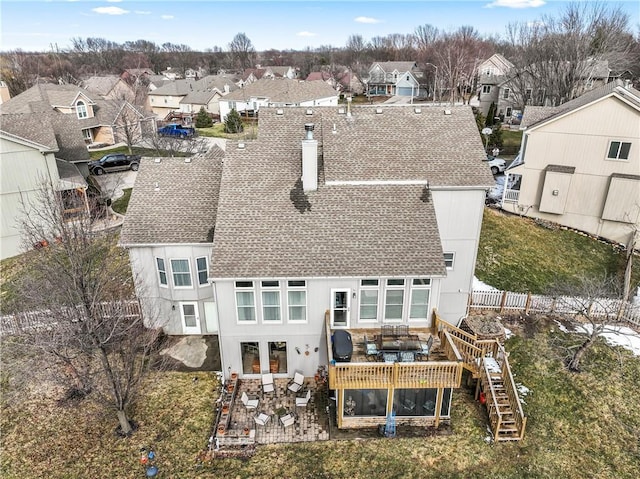 back of house with fence, stairway, roof with shingles, a residential view, and a chimney