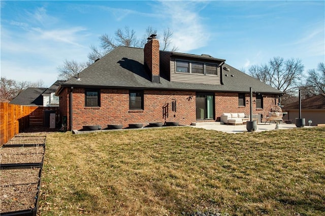 rear view of property with a patio area, a lawn, brick siding, and fence