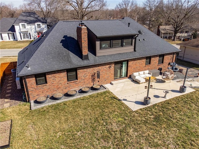 back of house featuring a patio, a chimney, a yard, and roof with shingles