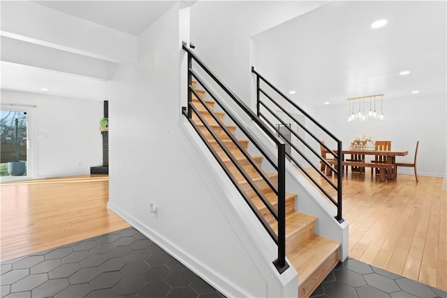 stairway featuring an inviting chandelier, recessed lighting, wood finished floors, and baseboards