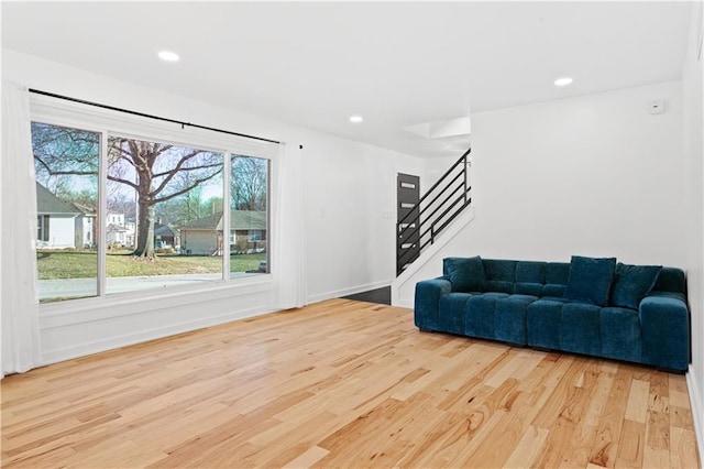 living room featuring stairway, recessed lighting, wood finished floors, and baseboards