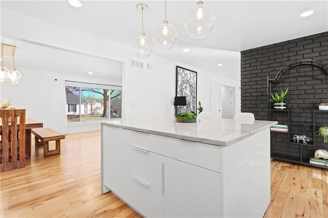 kitchen with white cabinetry, modern cabinets, light wood-type flooring, and a kitchen island