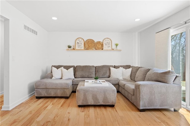 living room with recessed lighting, light wood-style floors, visible vents, and baseboards