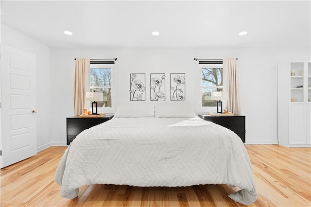 bedroom with recessed lighting, baseboards, multiple windows, and light wood-style flooring