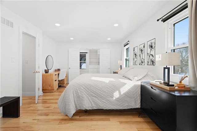 bedroom with light wood finished floors, visible vents, and recessed lighting