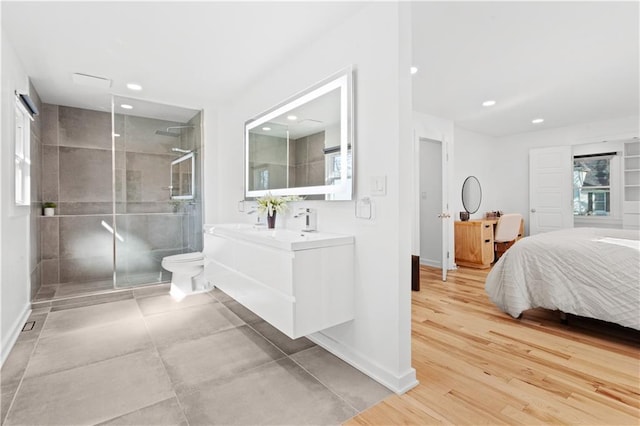 bedroom with light wood finished floors, recessed lighting, baseboards, and multiple windows