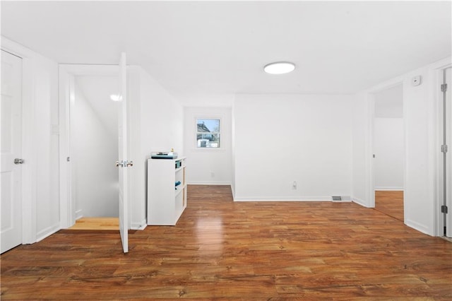 basement with wood finished floors, visible vents, and baseboards