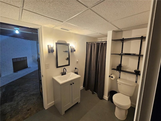 bathroom featuring vanity, visible vents, a fireplace, a paneled ceiling, and toilet