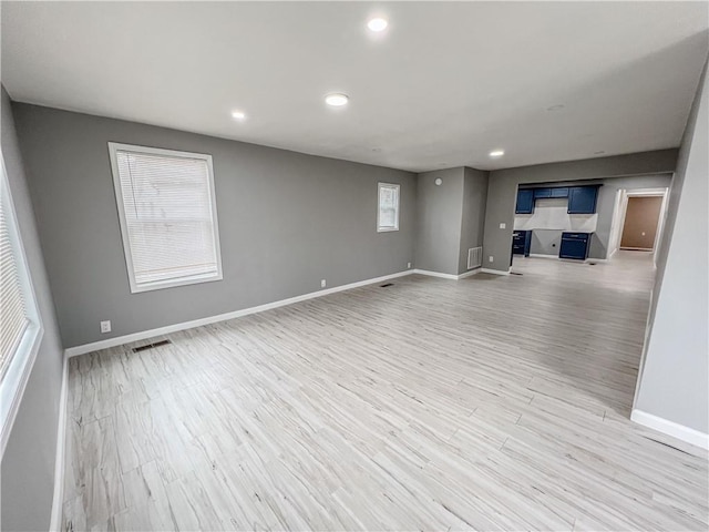 unfurnished living room with recessed lighting, visible vents, light wood-style flooring, and baseboards