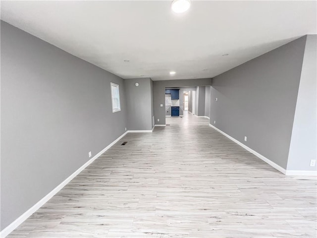 empty room featuring light wood-type flooring, baseboards, and recessed lighting