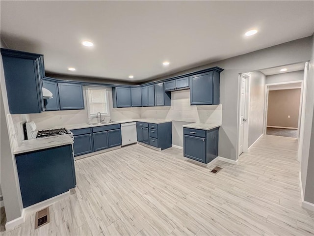 kitchen with recessed lighting, light wood-style floors, a sink, gas range, and dishwasher