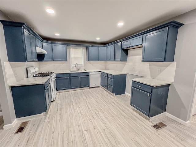 kitchen featuring dishwashing machine, visible vents, white gas stove, and a sink