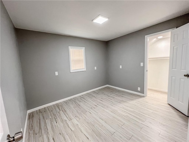 empty room with light wood-style flooring and baseboards