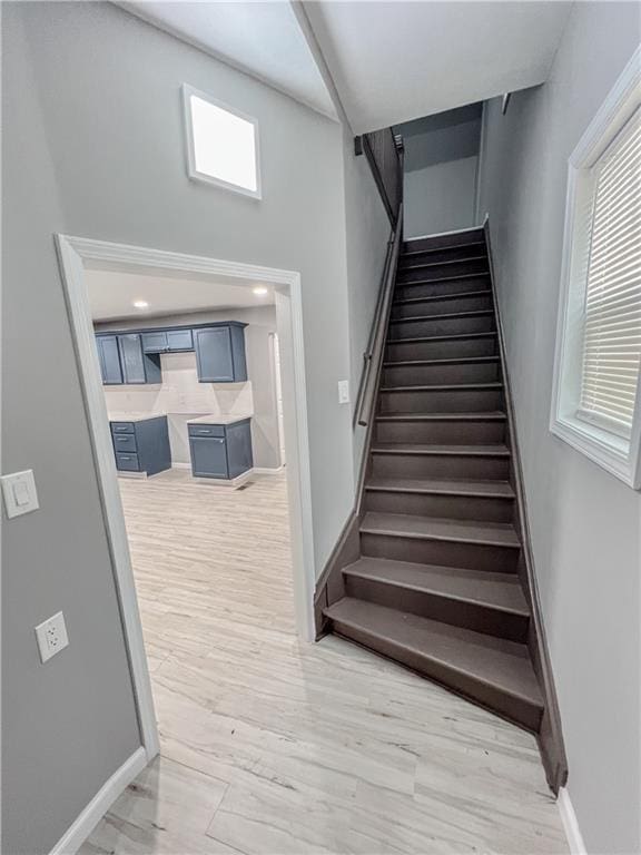 stairway with baseboards and wood finished floors