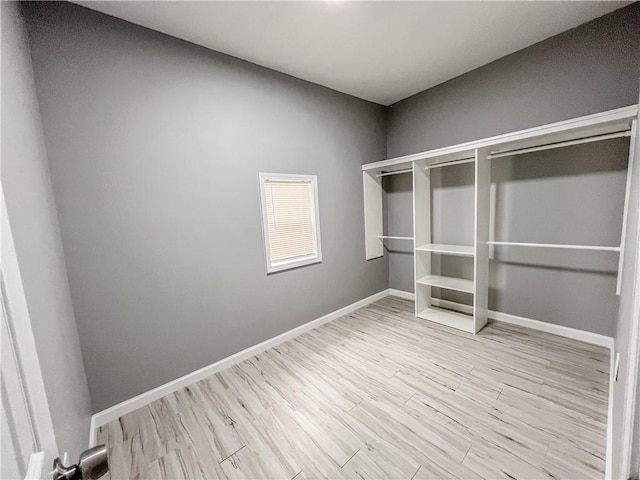 walk in closet with wood finished floors