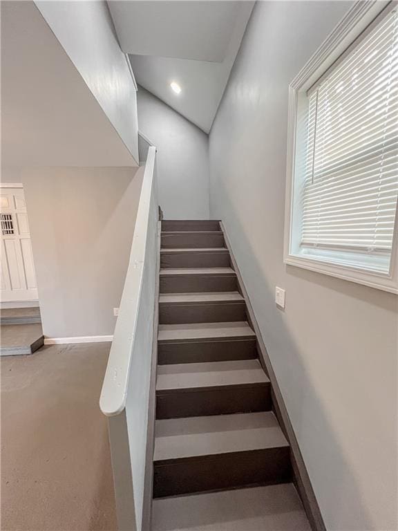 stairway featuring recessed lighting, plenty of natural light, and baseboards