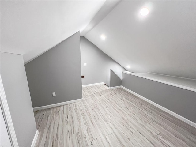 bonus room with lofted ceiling, baseboards, and wood finished floors