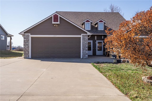 view of front of home featuring concrete driveway, stone siding, a garage, and roof with shingles